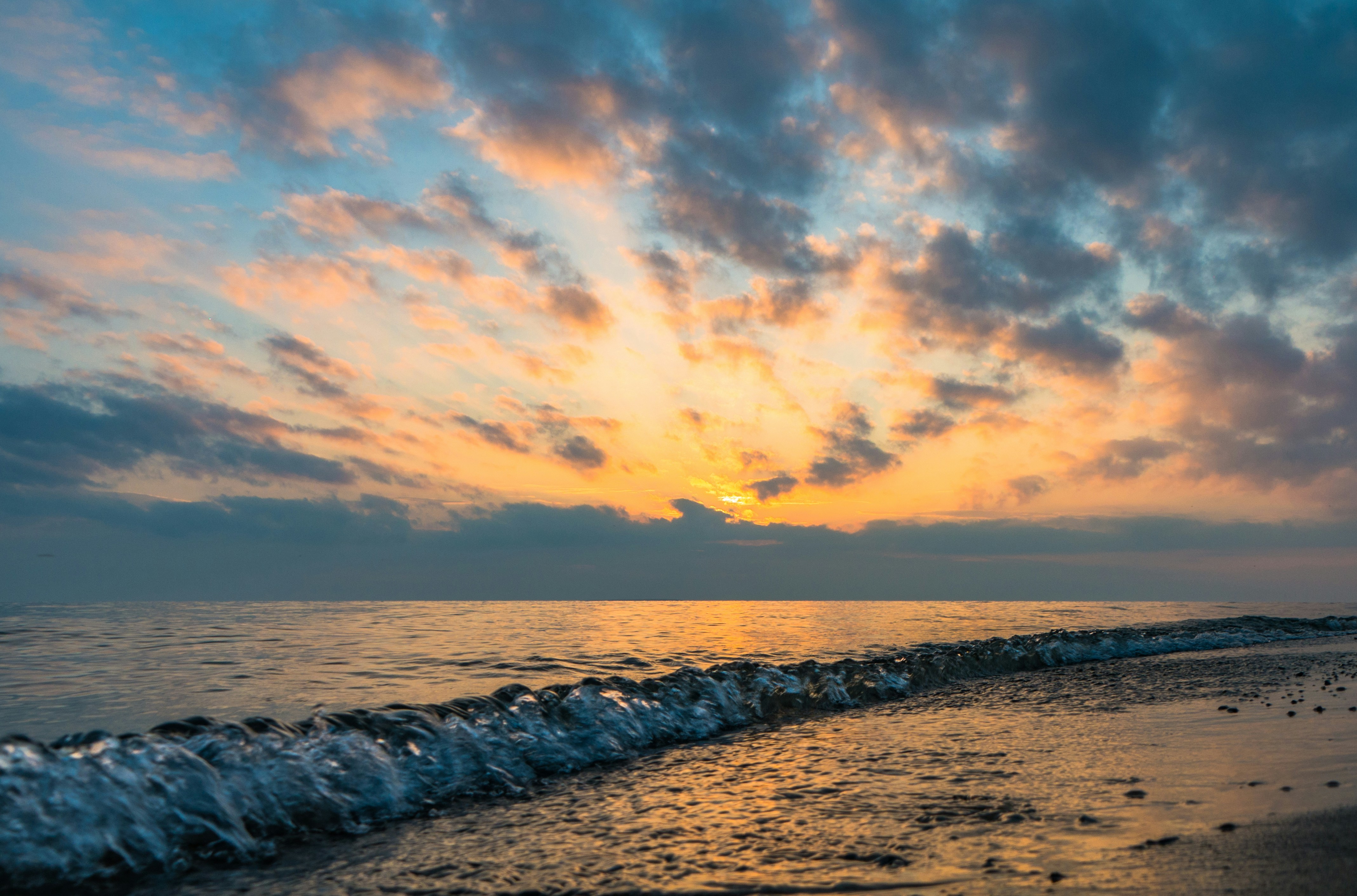 A serene view of Lake Huron with clear blue waters and a sandy beach.