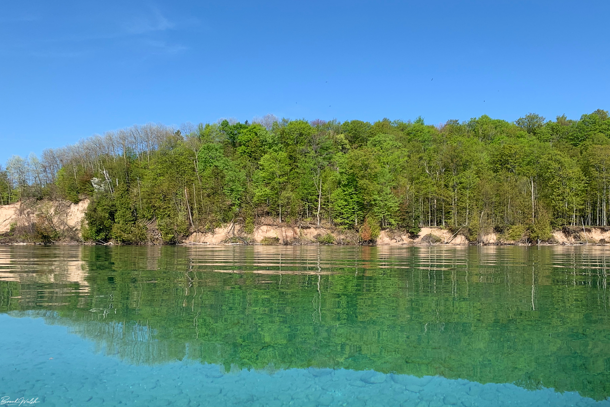 A serene view of Lake Leelanau with boats and lush greenery, perfect for a first-time visit.