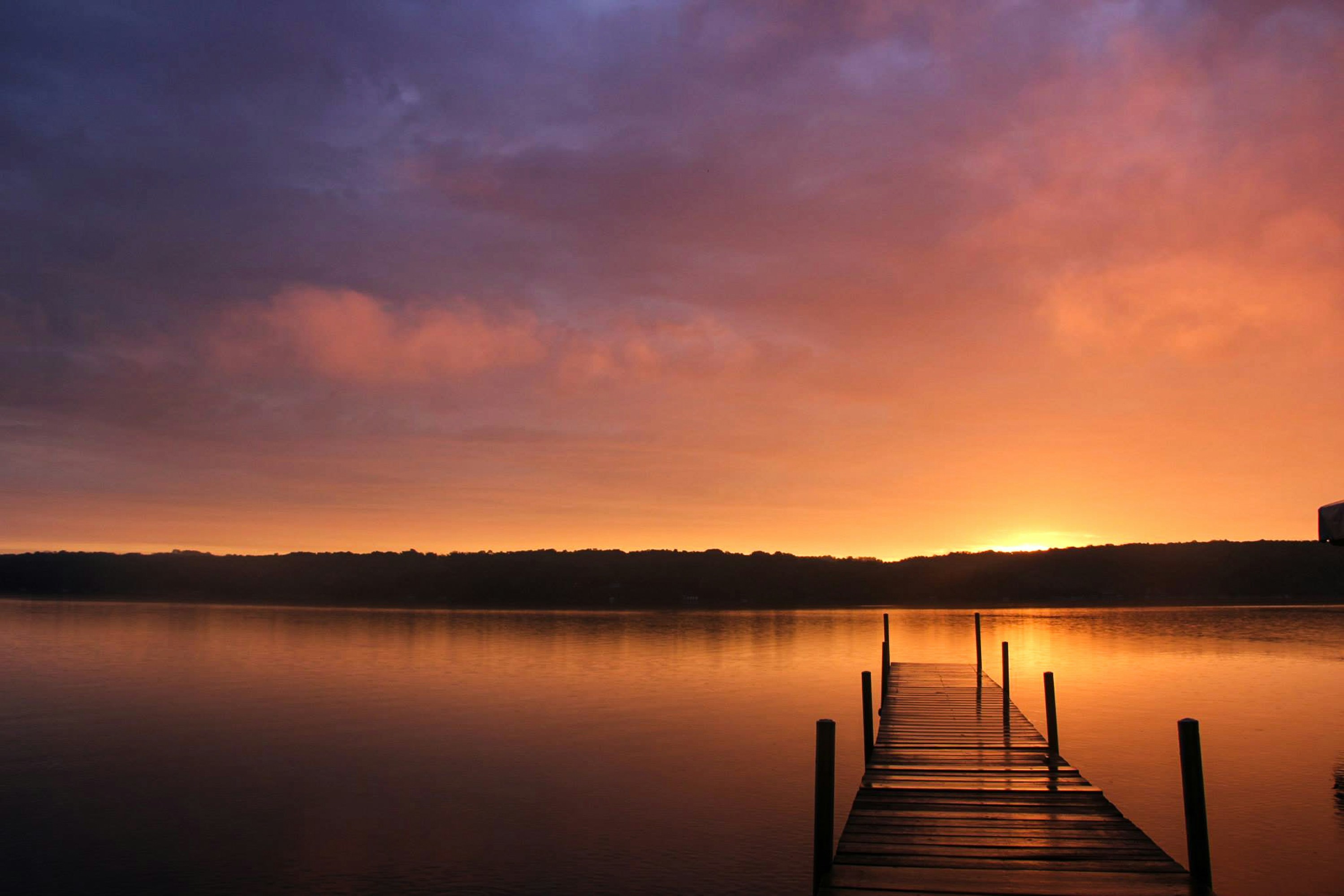 A scenic view of Walloon Lake with clear, deep blue waters surrounded by lush greenery.
