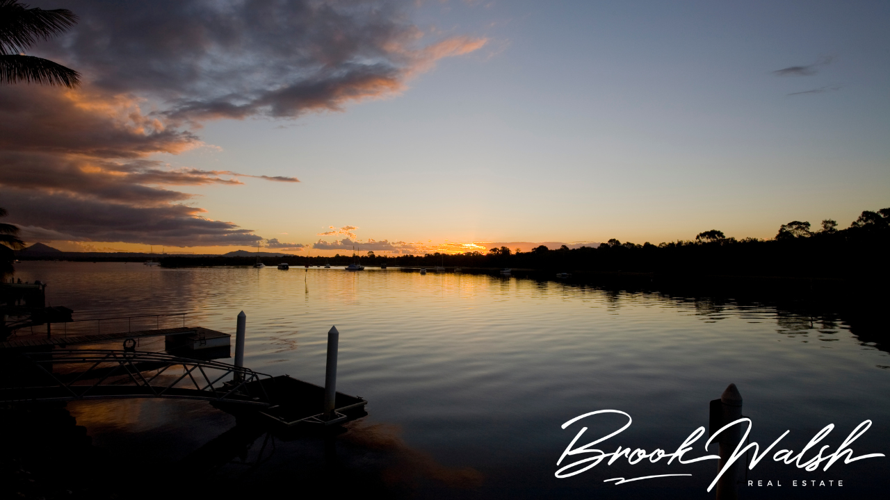 A picturesque view of a lakeshore with trees in the background and a dock stretching into the water.