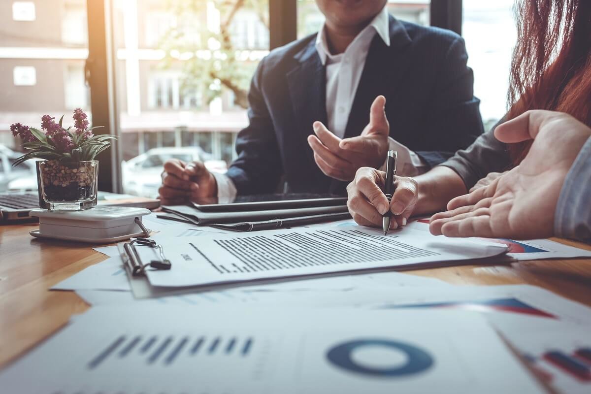 People looking at investment details on a desk