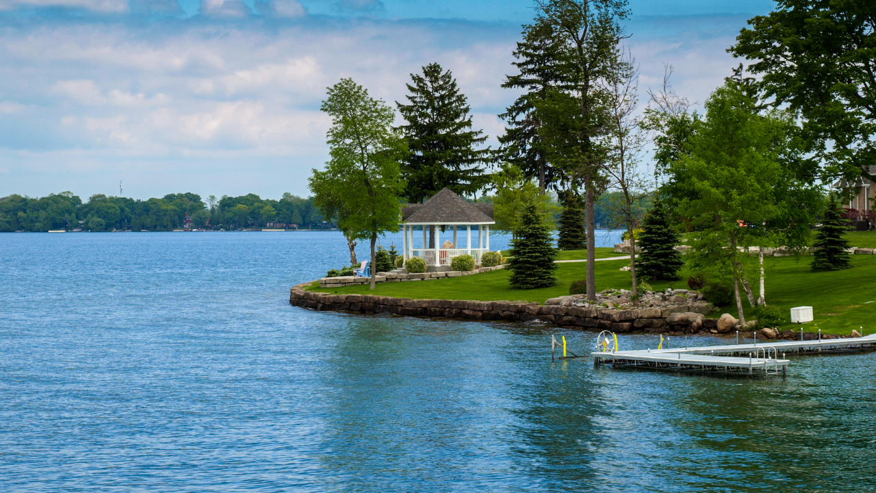 A beautiful view of Burt Lake, Northern Michigan with crystal-clear water and lush green trees in the background.