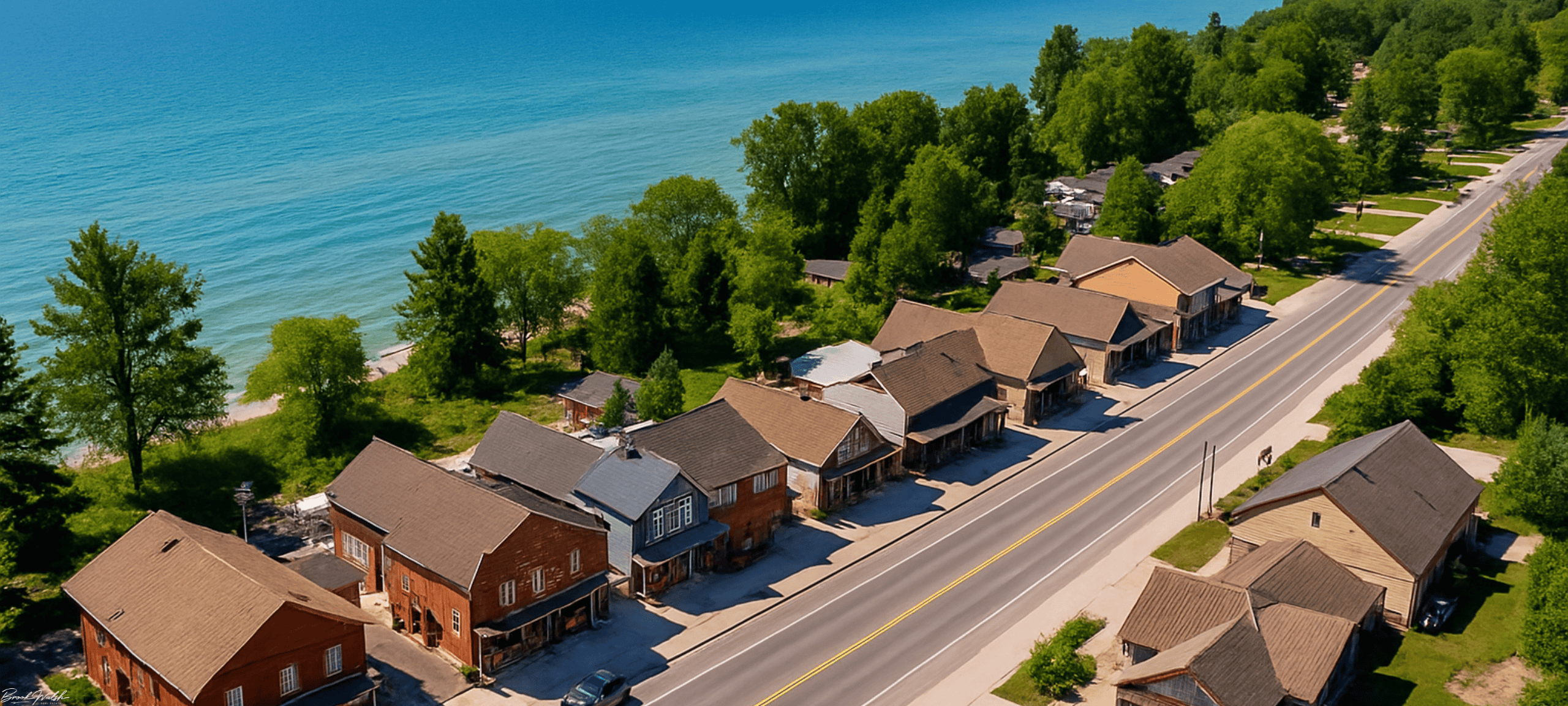 Aerial view of commercial storefronts along Lakeshore Drive in Cross Village, MI, with Lake Michigan in the background.