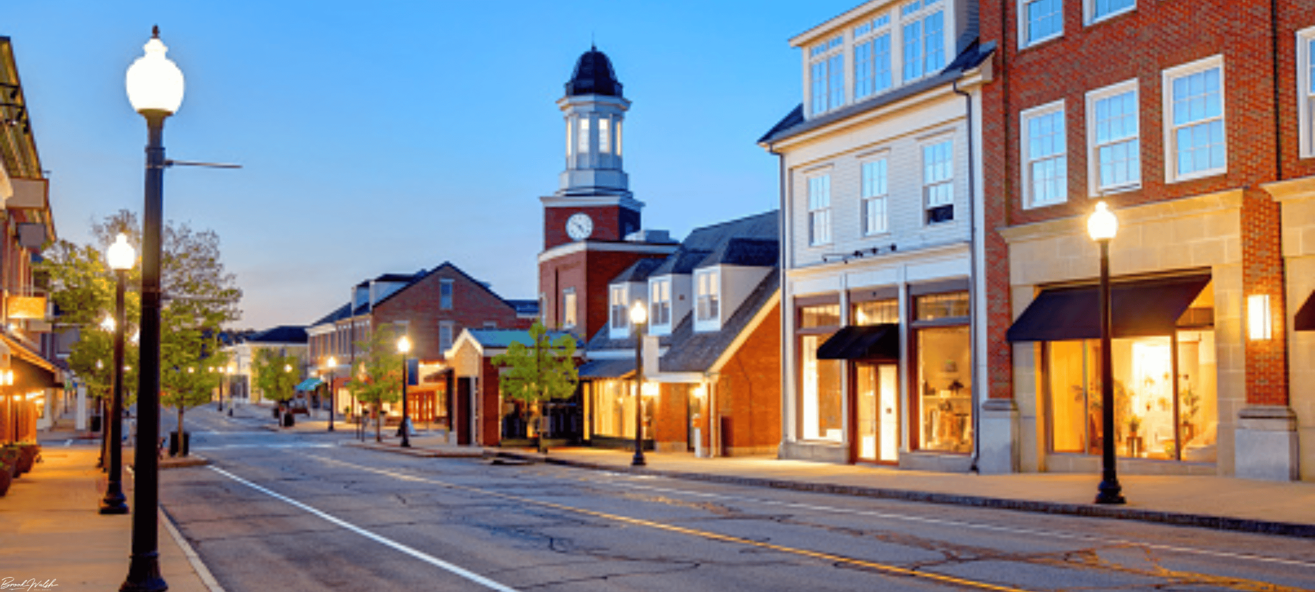 Scenic view of Downtown Frankfort, Michigan with shops, beach, and lighthouse on a sunny day