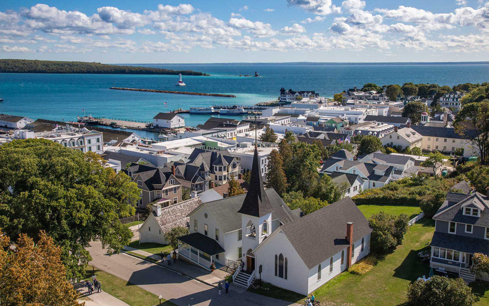 Scenic view of Mackinac Island with bicycles, horse-drawn carriages, and historic buildings.