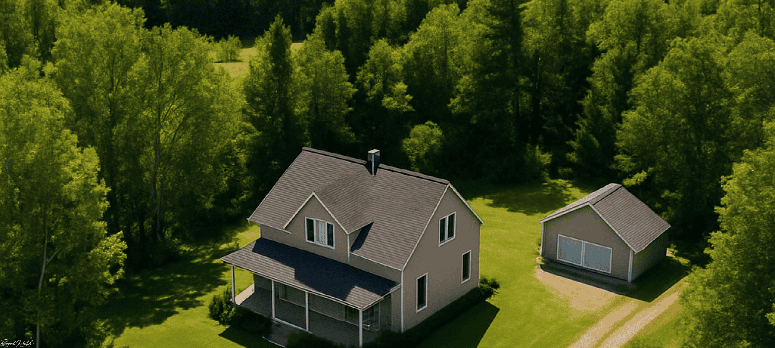 Aerial view of a land lover home in Tawas City surrounded by trees