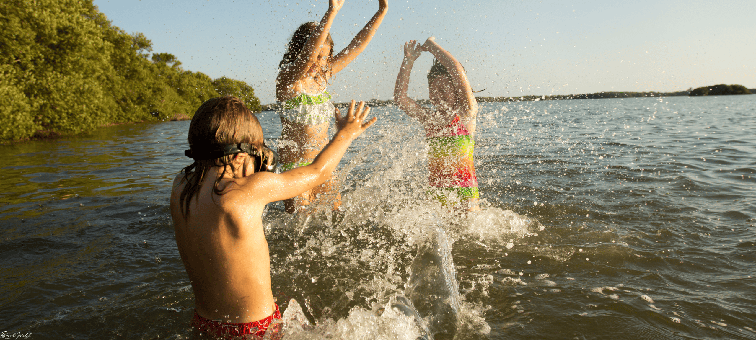 Swimmers enjoying clear blue waters at Walloon Lake beach on a sunny summer day
